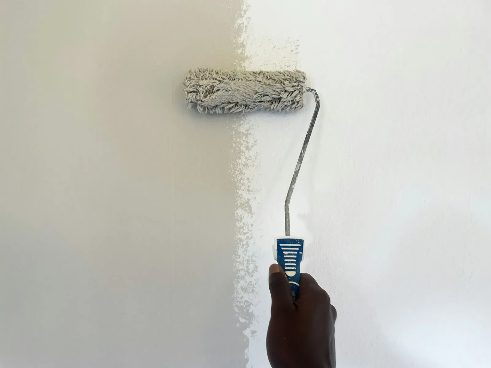Aplicación de microcemento y pintura sobre una pared en una reforma
